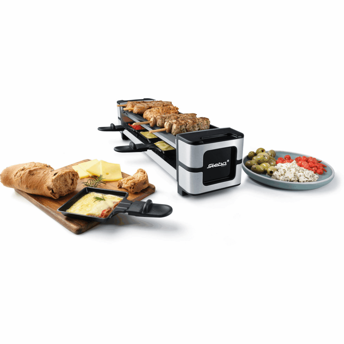 Raclette-Grill von Steba mit Grillfläche, Pfännchen für Käse, Brot und Beilagen wie Oliven und Tomaten auf einem Tisch.