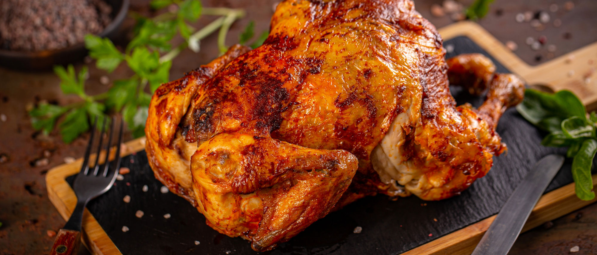 Ein knusprig gebratenes Hähnchen mit goldbrauner Haut.