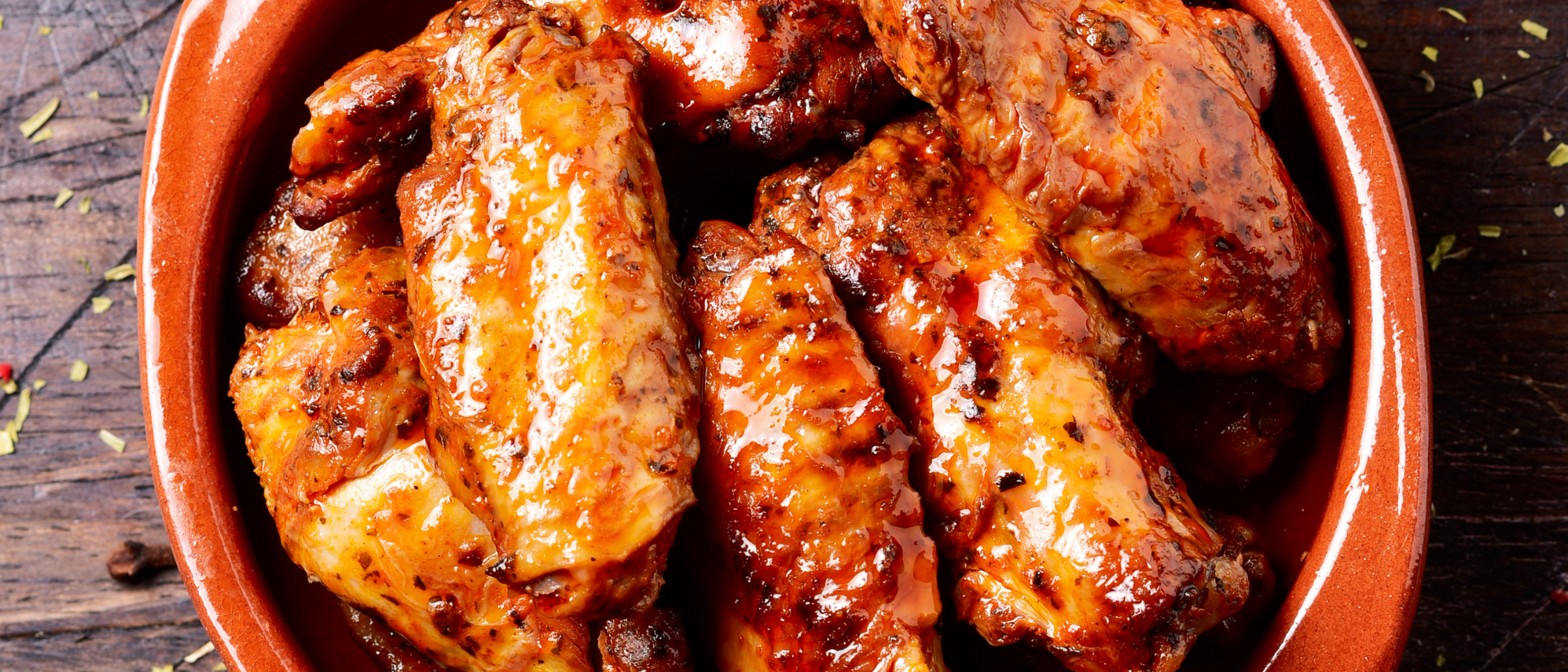 Saftige Chicken Wings in einer Schüssel, mit glänzender Soße überzogen und dicht angerichtet.