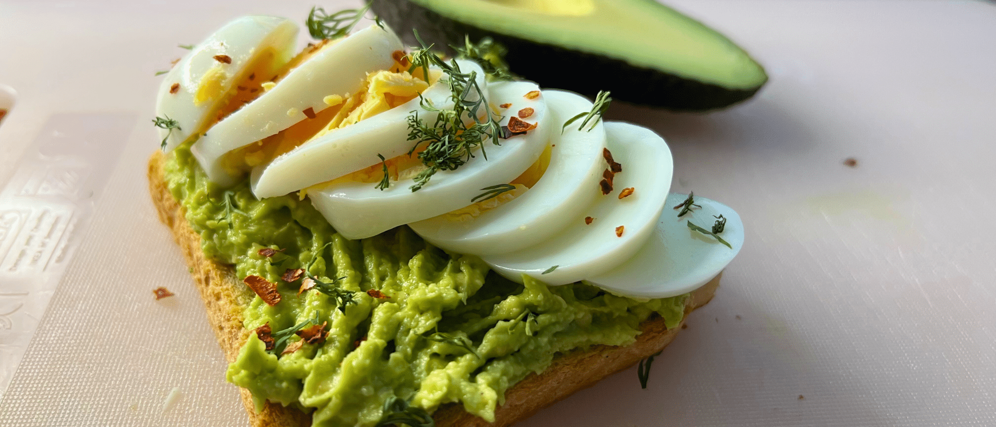 Hartgekochte Eier auf einem Avocadobrot.